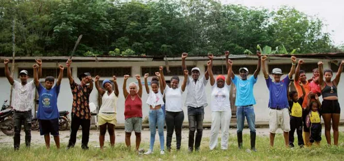 a line of villagers raising their fists for the camera
