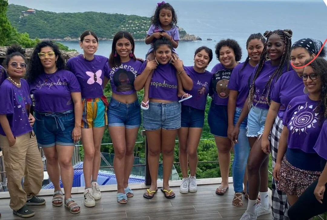 group of young women posing for photo near water